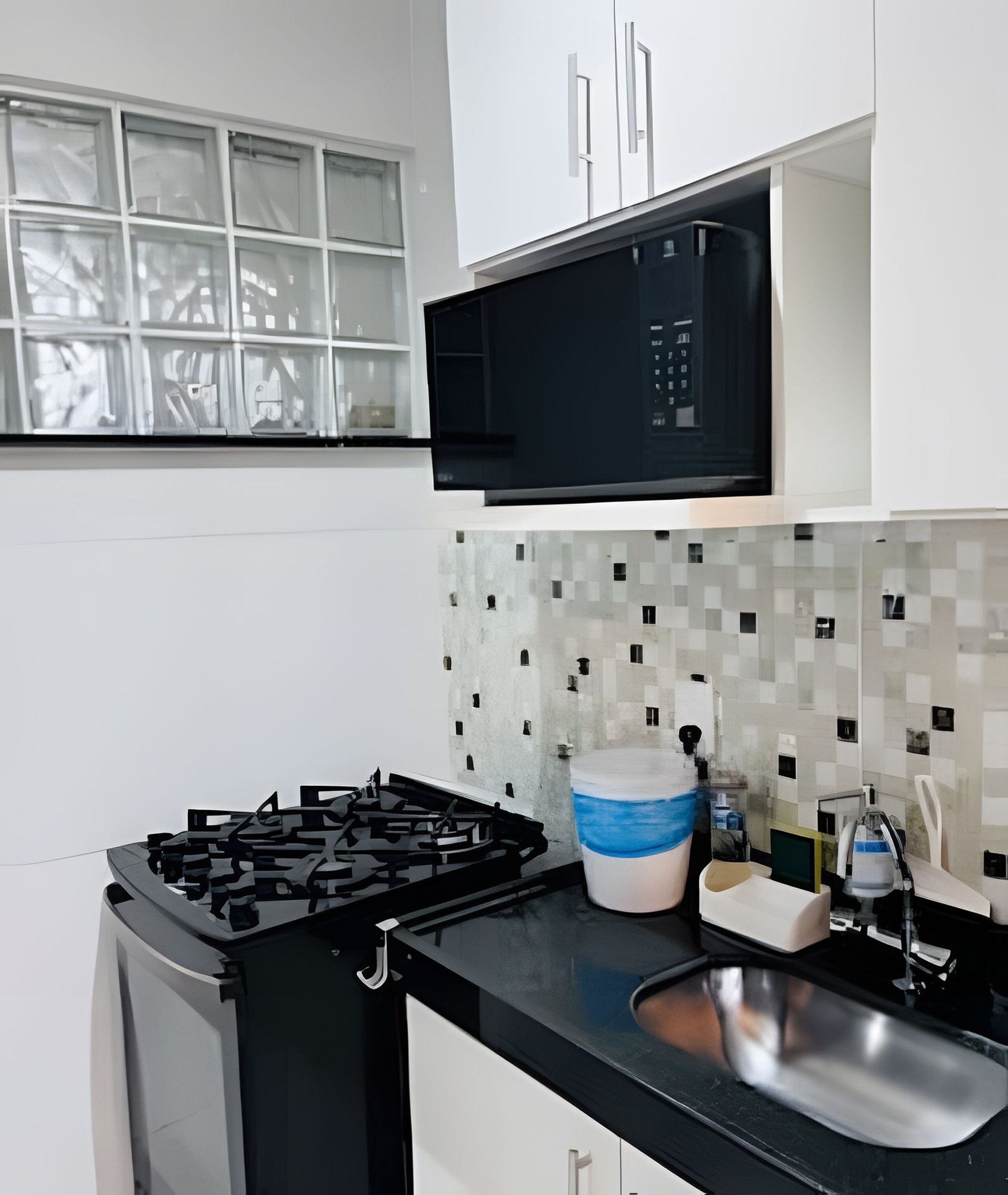 A modern kitchen with a gas stove, a microwave, and a sink.