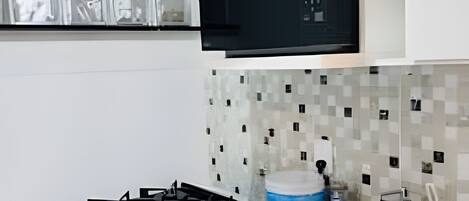 A modern kitchen with a gas stove, a microwave, and a sink.