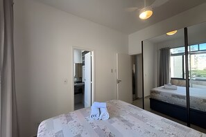 Habitación de hotel con cama, baño y vistas al exterior.