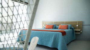 A bedroom with a bed, a headboard, and a window with a view. - Casas Bioclimáticas Iter La Religa (Granadilla de Abona)