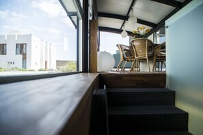 Ein modernes Interieur mit Blick auf ein Gebäude, eine Treppe und Korbmöbel.