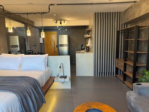 A modern hotel room with a bed, kitchenette, and a bar area. - Style & Comfort - SampaSky (São Paulo)