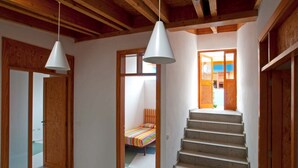 A staircase leading to a bedroom with a bed and a colorful striped blanket. - Casas Bioclimáticas Iter Noche y Dia (Granadilla de Abona)