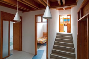 A staircase leading to a bedroom with a bed and a colorful striped blanket. - Casas Bioclimáticas Iter Noche y Dia (Granadilla de Abona)