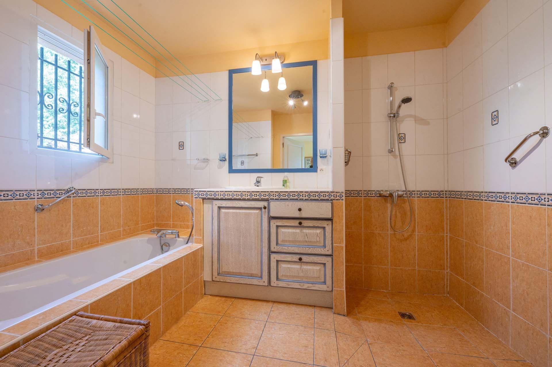 Un bagno con vasca, doccia, lavandino e specchio.