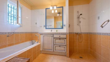 Un bagno con vasca, doccia, lavandino e specchio.