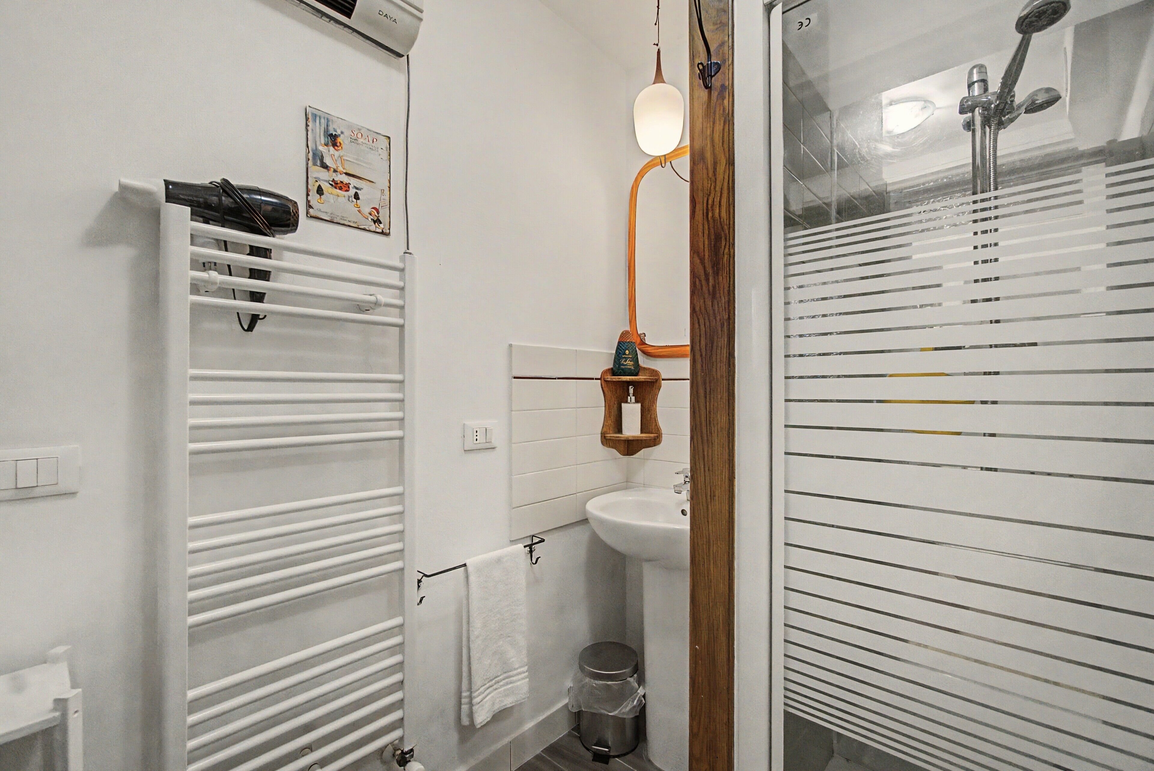 A bathroom with a white bathtub, a sink, and a towel rack.