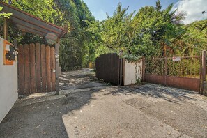 A gated driveway leading to a building with a wooden fence and a metal gate. - Apartment 'Camera Giuly' with Shared Garden, Wi-Fi and Air Conditioning (Venice)