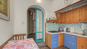 Una cocina funcional con estufa, microondas y un reloj en la pared.