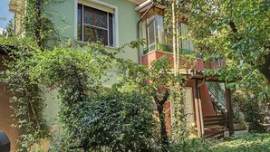 A two-story building with a green facade, a visible window, and a staircase leading to the upper floor. - 'Camera Mini' Apartment with Shared Garden, Wi-Fi and Air Conditioning (Venice)