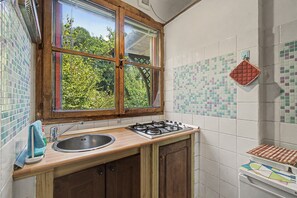 Eine Küche mit Fenster, Spüle, Herd und Schränken.