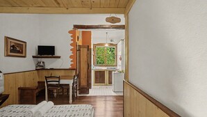 A room with a bed, a desk, a chair, a television, and a window. - 'Camera Mini' Apartment with Shared Garden, Wi-Fi and Air Conditioning (Venice)