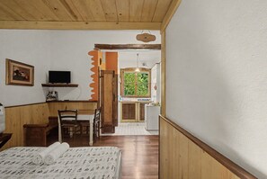 Ein Zimmer mit einem Bett, einem Schreibtisch, einem Stuhl, einem Fernseher und einem Fenster.