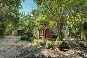 A garden with a pathway leading to a building with a red door. - 'Camera Petit' Apartment with Shared Garden, Wi-Fi and Air Conditioning (Venice)