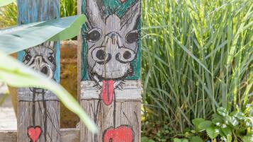 Una estructura de madera con rostros de animales pintados y corazones.