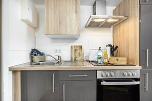 Eine moderne Küche mit einer Spüle aus Edelstahl, einem eingebauten Backofen und einer Holz Arbeitsplatte.