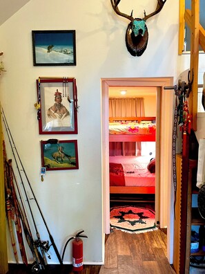 Ein Zimmer mit einem Etagenbett, Bildern an der Wand und Angelruten.