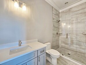 A modern bathroom with a glass-enclosed shower, a white sink, and a toilet. - Vista Del Mar: New Construction, Beach Views, Private Pool, Pet-Friendly, SGI Pl (St. George Island)