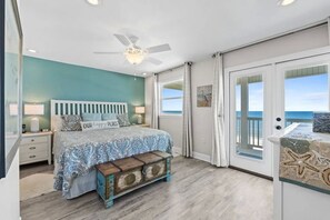 A bedroom with a bed, a nightstand, a bench, a ceiling fan, and a view of the ocean through a sliding door. - Aloha House – Gulf-Front Retreat on Cape San Blas (Cape San Blas)