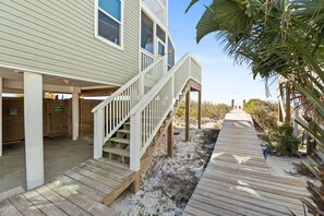 A beachfront property with a wooden deck, a covered porch, and a staircase leading to a second level. - Aloha House – Gulf-Front Retreat on Cape San Blas (Cape San Blas)