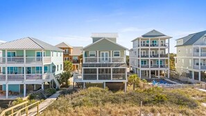 A beachfront residential area with multi-story buildings, balconies, and a wooden walkway. - Aloha House – Gulf-Front Retreat on Cape San Blas (Cape San Blas)