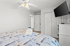 A bedroom with a bed, a ceiling fan, a television, and a wardrobe. - Aloha House – Gulf-Front Retreat on Cape San Blas (Cape San Blas)