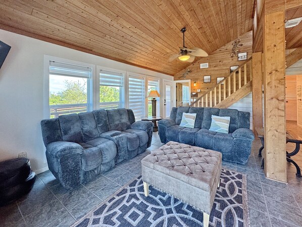 A spacious living area with two sofas, a coffee table, and a staircase. - The Lookout: North Cape, 3 Bedrooms, Pet-Friendly, Private Pool! Short walk to b (Cape San Blas)