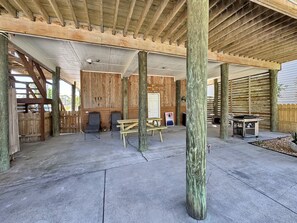 An outdoor covered patio area with wooden beams, concrete flooring, and seating arrangements. - The Lookout: North Cape, 3 Bedrooms, Pet-Friendly, Private Pool! Short walk to b (Cape San Blas)