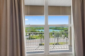 Een balkon met uitzicht op water en groen.