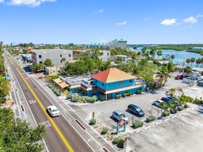 Ein Hotel an der Küste mit Parkplatz, einer Straße mit Zebrastreifen und Blick auf das Meer.