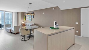 A modern interior with a dining area, a sofa, and a kitchen island with a water dispenser. - Waterfront Oasis With Resort Amenities (Hollywood)
