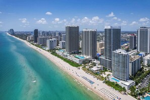 Eine Küstenstadt mit Hochhäusern, einem Strand und blauem Himmel.