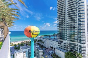 A view of a hotel with a large building, a swimming pool, and a beach in the background. - Waterfront Oasis With Resort Amenities (Hollywood)