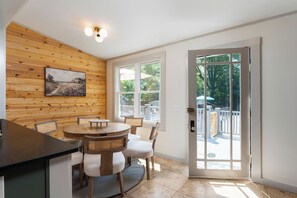 Ein Essbereich mit Holzwand, einem runden Tisch und Stühlen.
