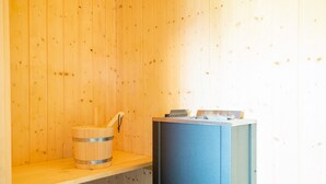 Un sauna avec des murs en bois, un banc en bois et un banc de sauna bleu.
