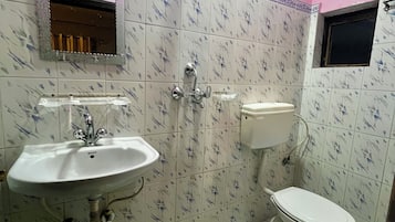 A bathroom with a sink, toilet, and shower.