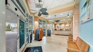 A hotel lobby with a reception desk, seating area, and a view of the street outside. - Carolinian Beach Resort 1735 (Myrtle Beach)