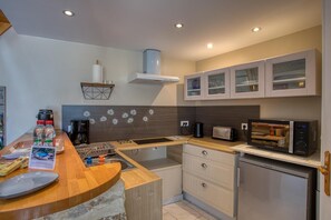 A modern kitchen with a built-in microwave, toaster, and coffee maker. - Hostcare - La Salamandre – swimming pool (Carlux)