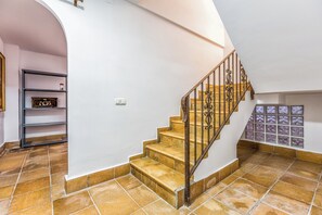 A staircase with a metal railing leading to a landing.