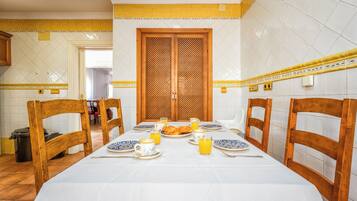 A dining area with a table set for breakfast, including plates, cups, and a croissant.
