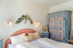 A bedroom with a bed, a dresser, and a wall-mounted light fixture. - Apartment Grattschlössl 3 with mountain view, balcony and Wi-Fi (Sankt Johann)