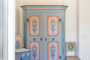 Ein Schrank mit floralen Mustern und einer Plakette mit der Aufschrift '18 Magdalena Gratt 89'.