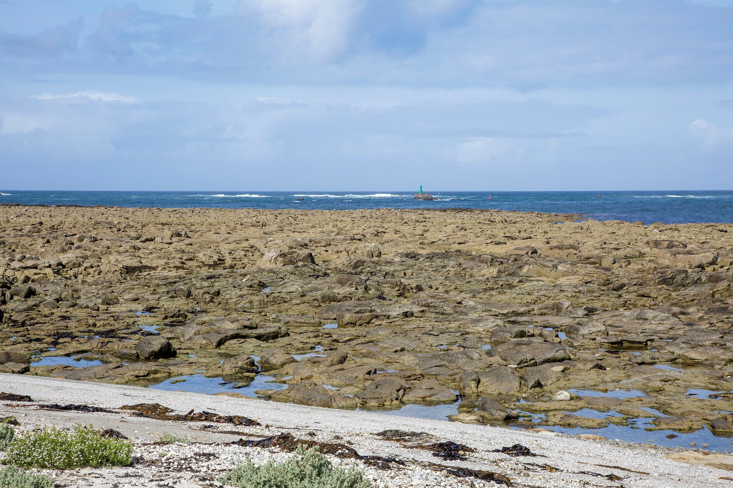 A rocky beach with a clear sky and calm sea.