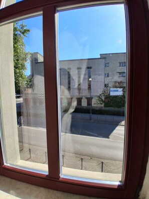 A window with a view of a building and a street.
