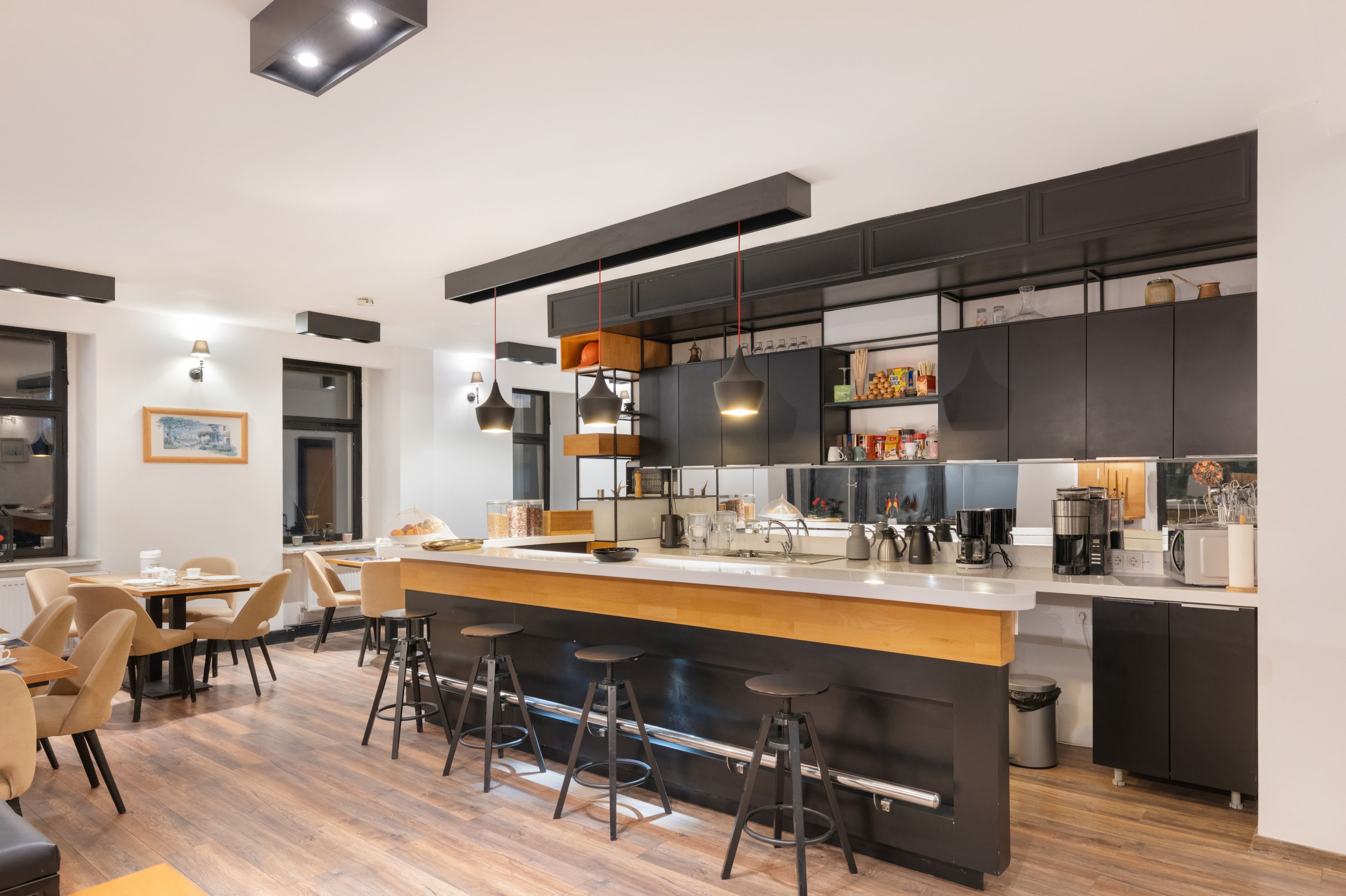 A modern kitchen with a central island, bar stools, and a dining area with chairs.