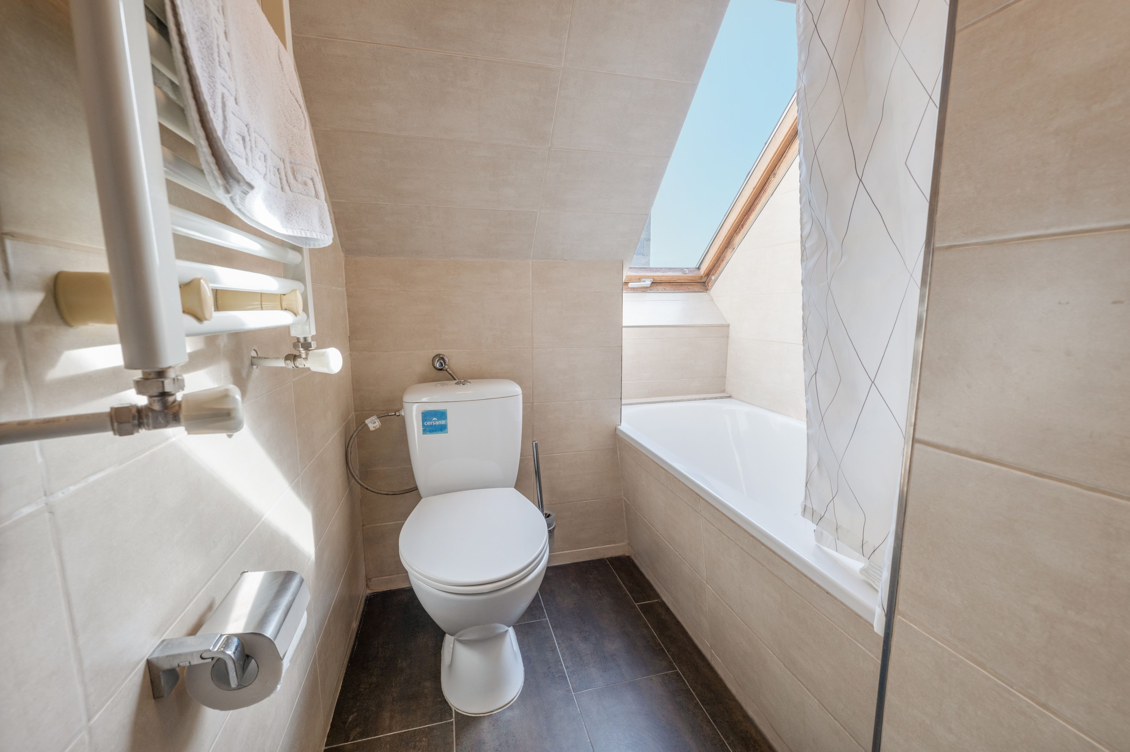 A compact bathroom with a toilet, a shower area, and a bathtub.