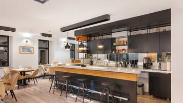 A modern kitchen with a central island, bar stools, and a dining area with chairs.