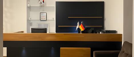 Una sala moderna con suelo de madera, un sofá, un televisor de pantalla plana y un reloj en la pared.