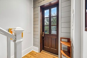 A wooden door with a window, a white wall, and a wooden floor. - Wally's World|Private Pool|Elevator|Golf Cart (Inlet Beach)