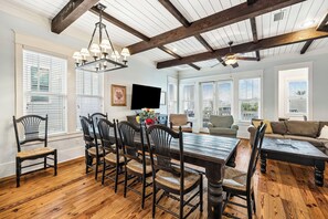 A dining area with a wooden table and chairs, a ceiling fan, and large windows. - Wally's World|Private Pool|Elevator|Golf Cart (Inlet Beach)